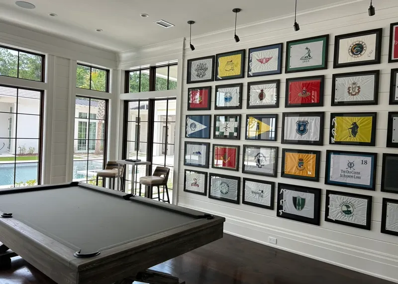 Framed golf flag collection displayed in game room with pool table